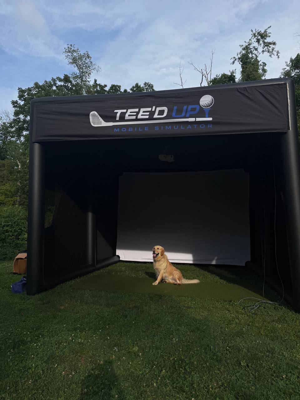Guests interacting around the Tee’d Up golf simulator setup
