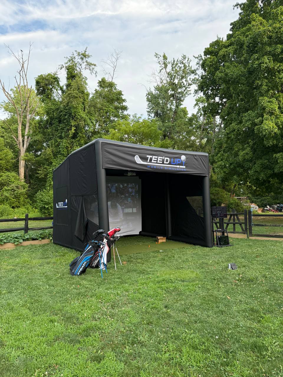 Guest taking a swing inside the Tee’d Up simulator